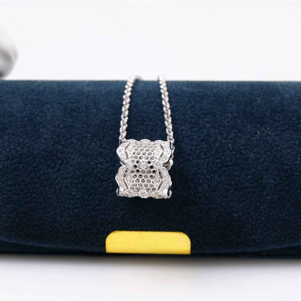 Silver necklace with a pendant on a blue cushion with a yellow bar