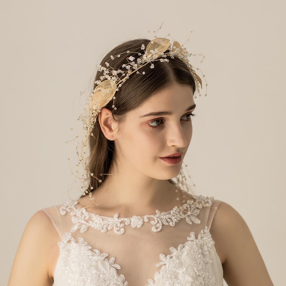 Woman wearing a decorative headpiece and a white lace dress against a beige background