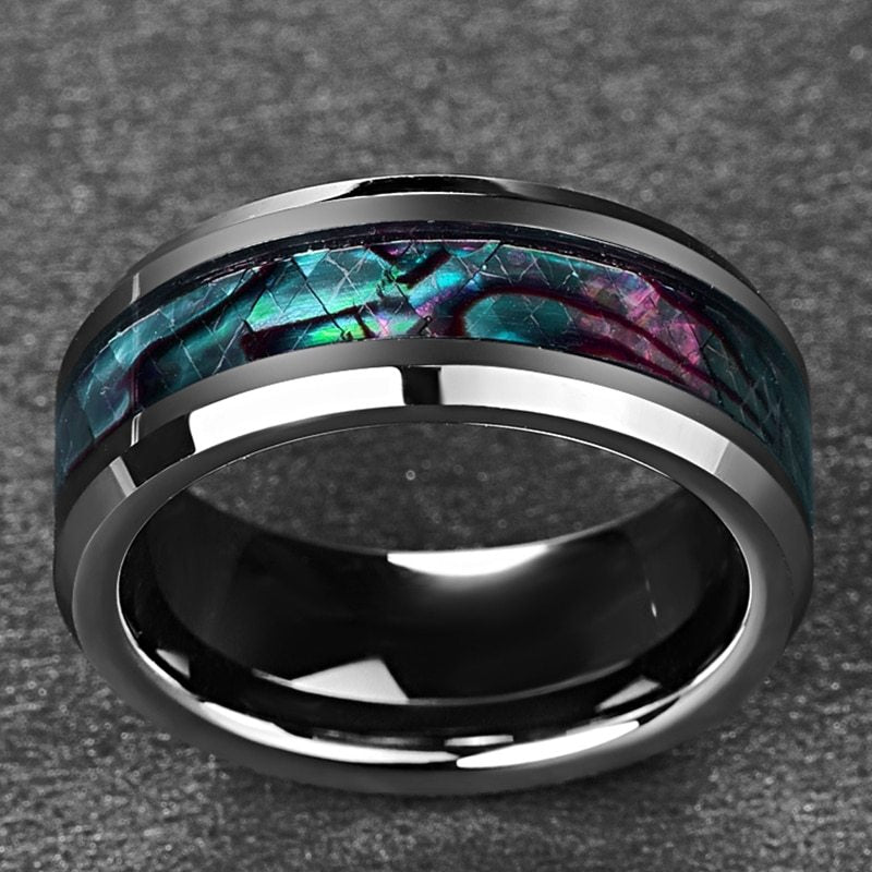 Black ring with colorful inlay on a textured gray background
