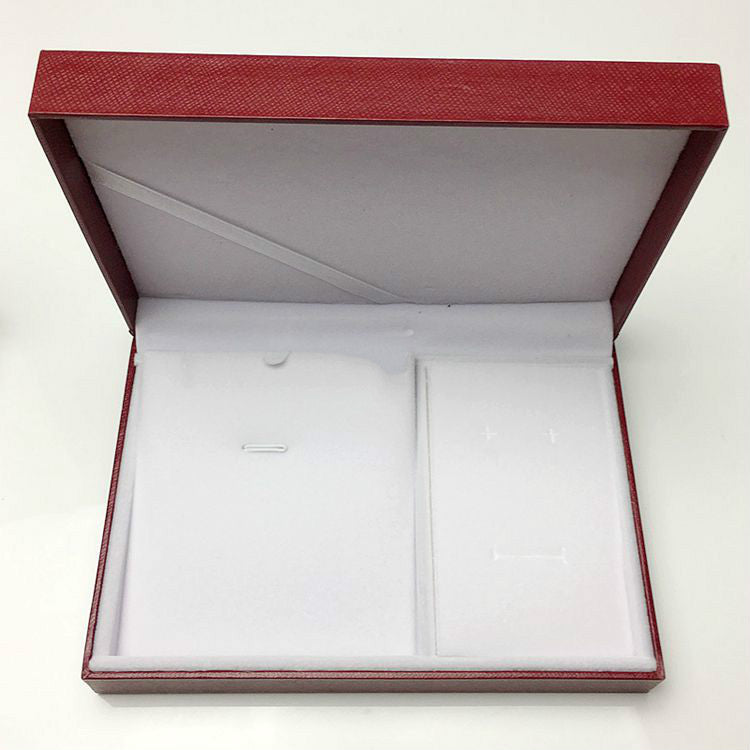 Open red jewelry box with a white interior on a white background