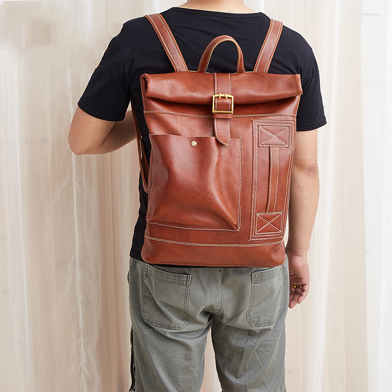 Person wearing a brown leather backpack against a neutral background