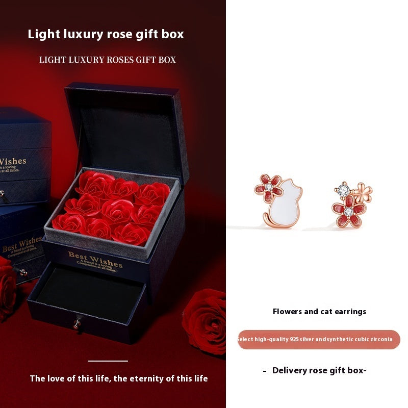 Light luxury rose gift box with red roses and earrings on a white background