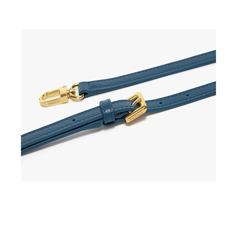 Blue leather strap with gold hardware on a white background