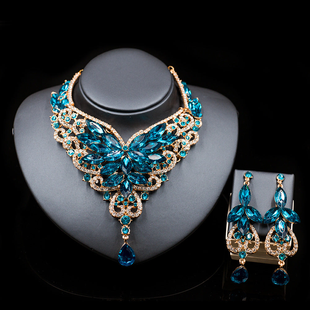 Jewelry set with blue and gold necklace and earrings on a black background