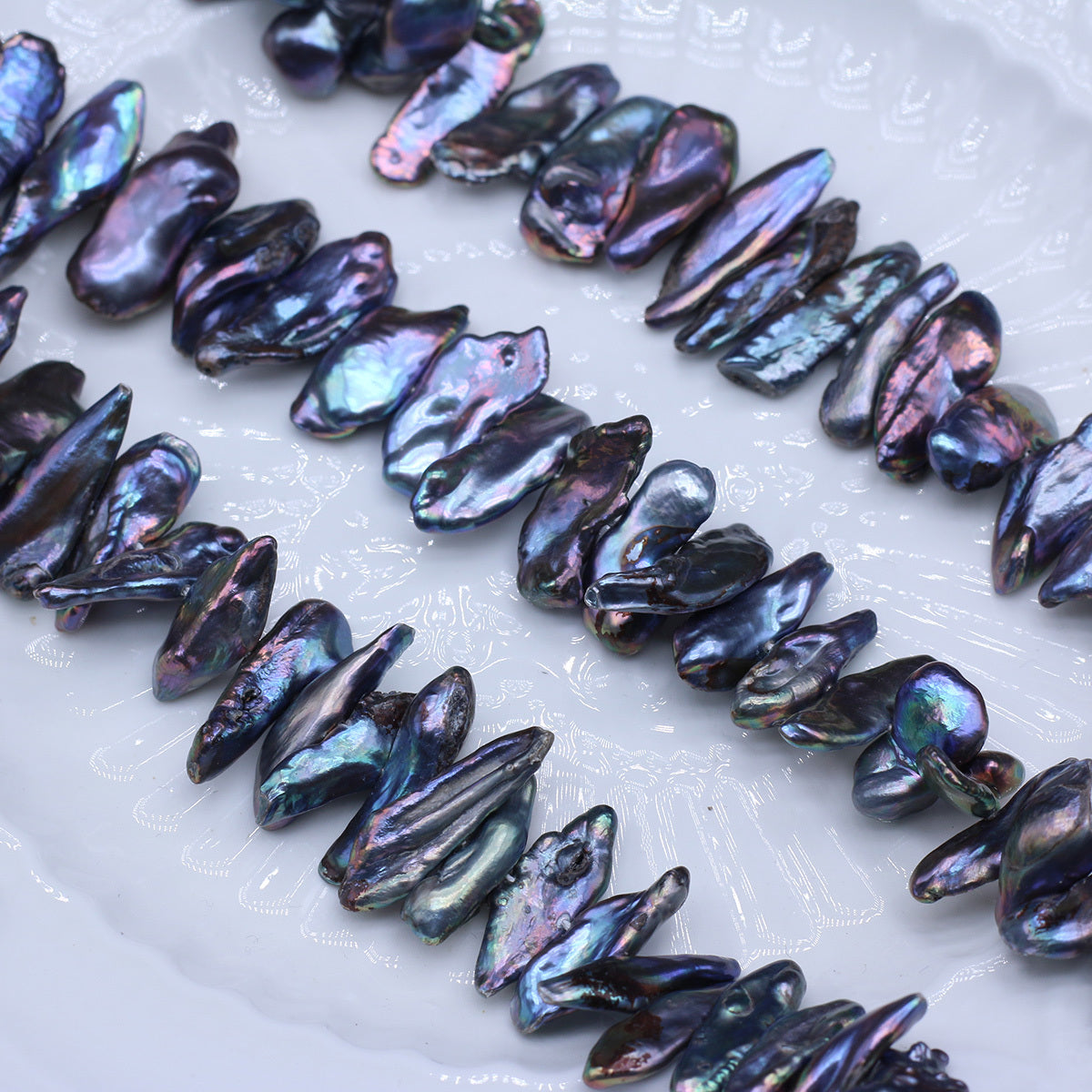 Iridescent shell beads on a white surface