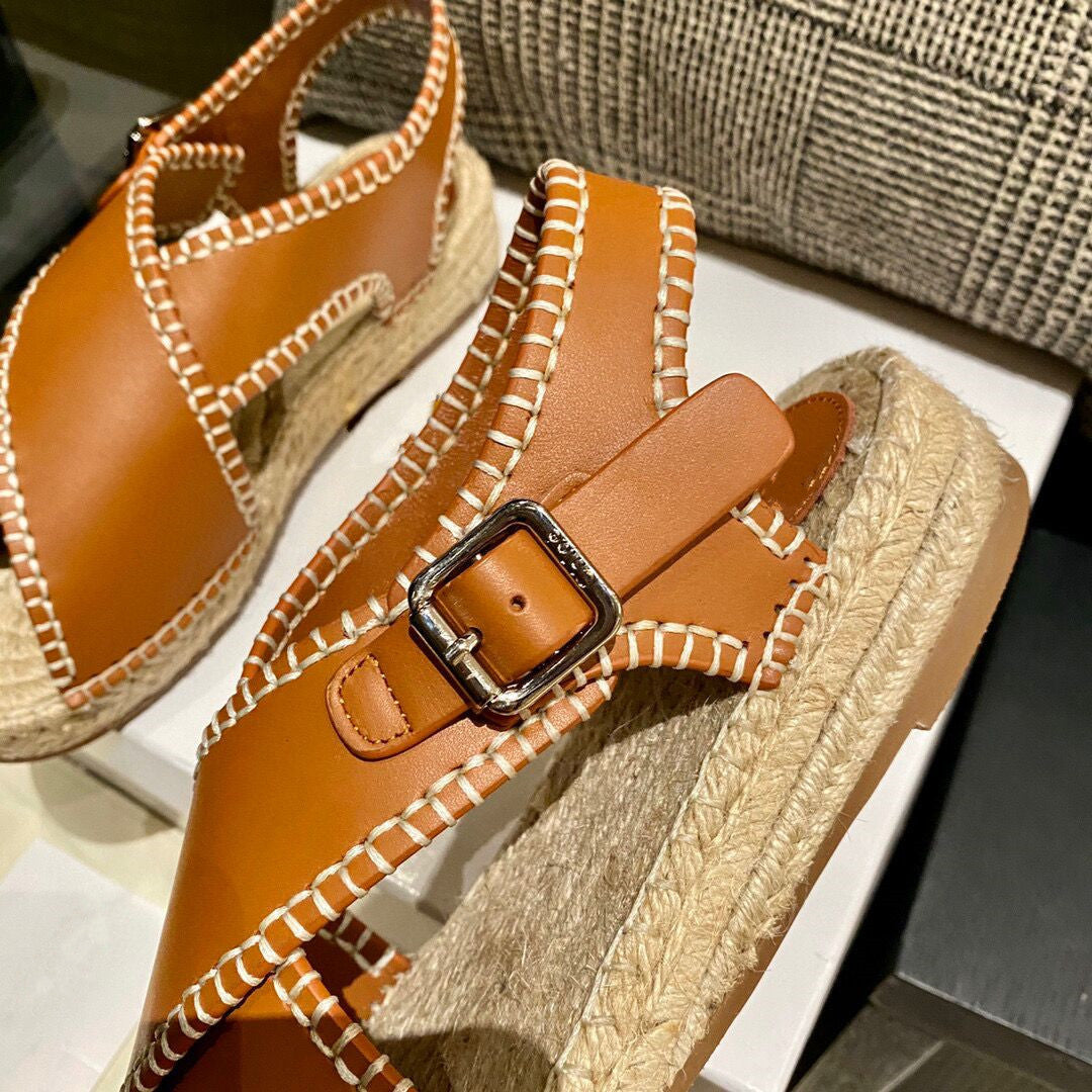 Brown sandal with a buckle on a white surface