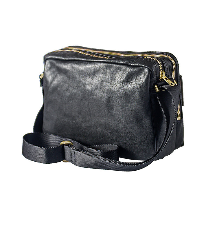 Black leather bag with gold zippers on a white background