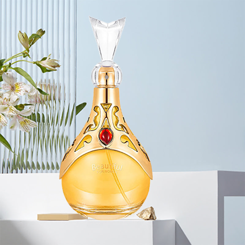 Decorative bottle with gold cap and red gem on a light blue background