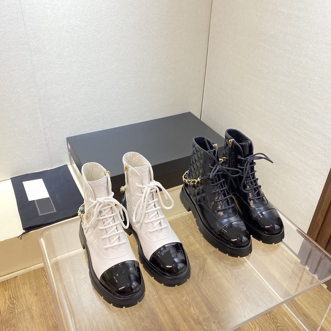 Pair of white and black boots on a clear surface with a neutral background