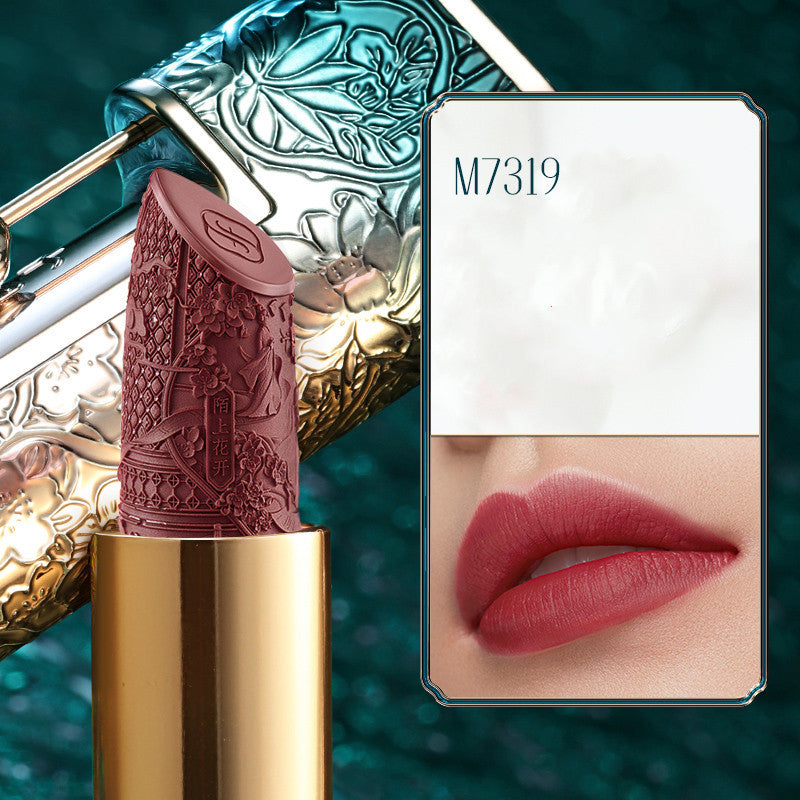 Lipstick with decorative case and color swatch on a teal background