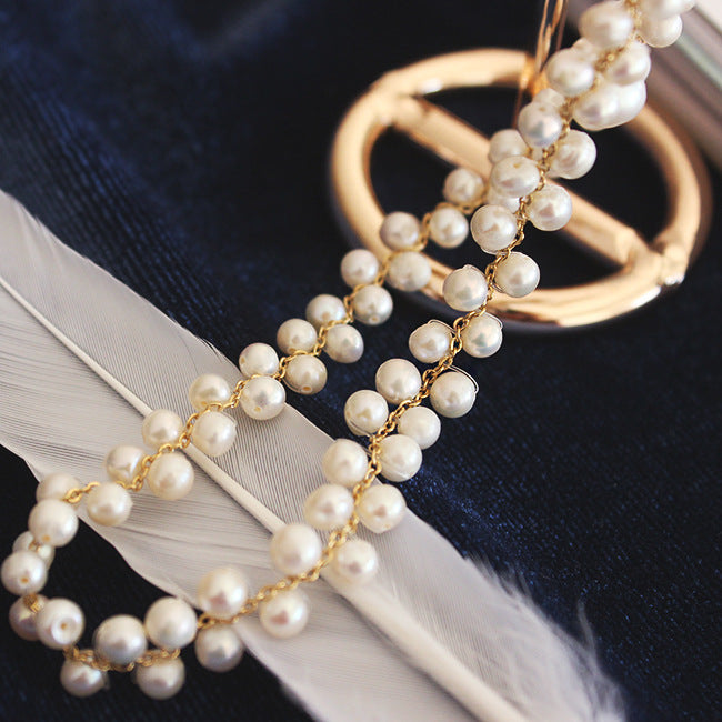 Pearl necklace with gold chain on a dark background