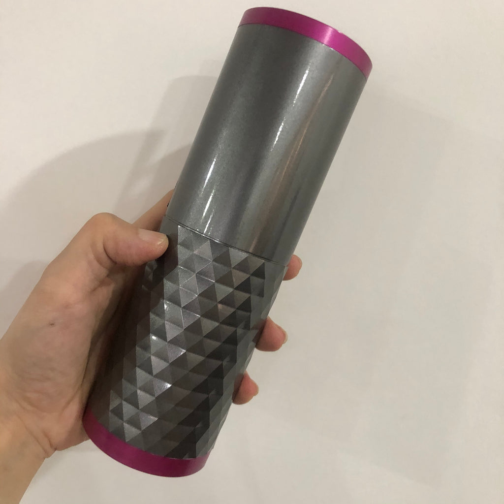Hand holding a gray tumbler with a purple top and bottom on a white background