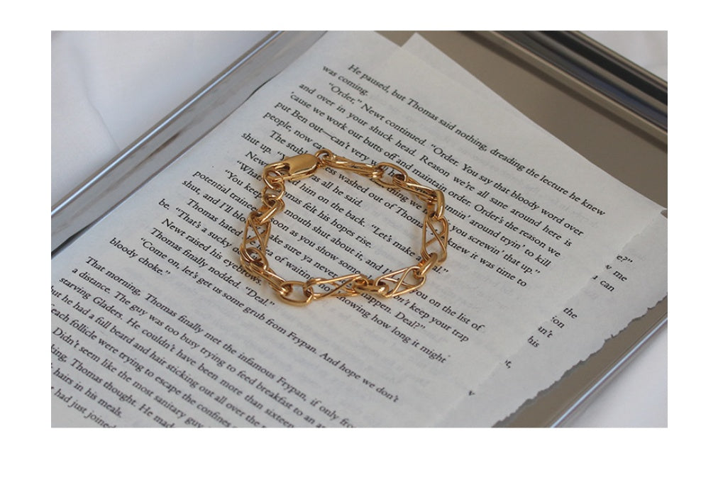 Gold chain bracelet on an open book