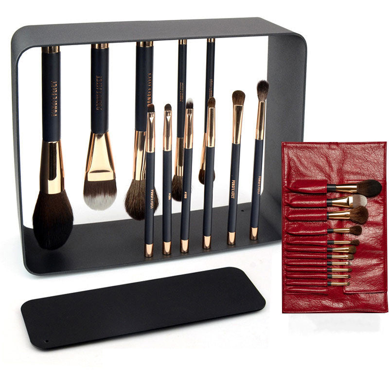 Set of makeup brushes with a black stand and red pouch on a white background