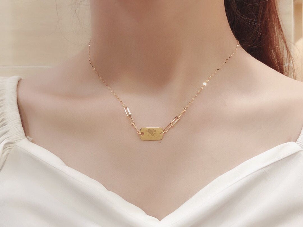 Gold necklace on a mannequin with a white top