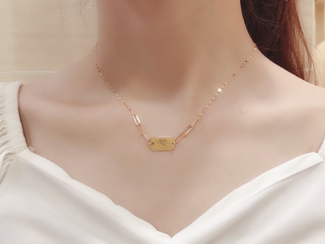 Gold necklace on a mannequin with a white top