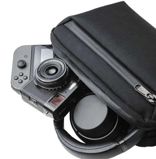 Camera with lens and accessories inside a black carrying case on a white background
