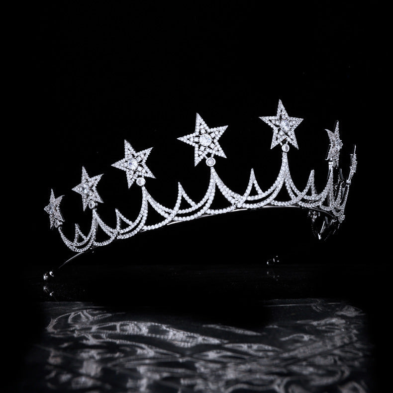 Silver tiara with star-shaped embellishments on a black background
