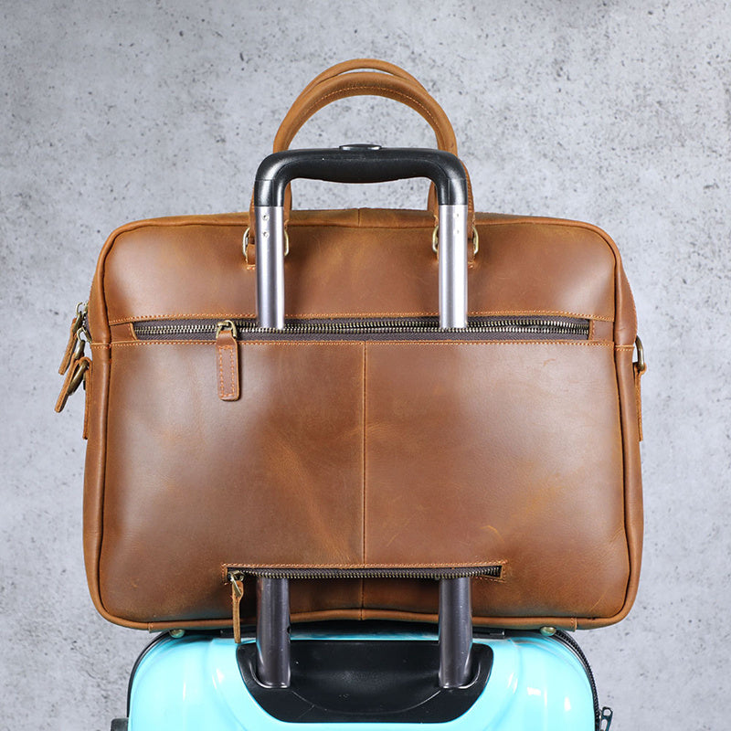 Brown leather briefcase with handle and wheels on a gray background