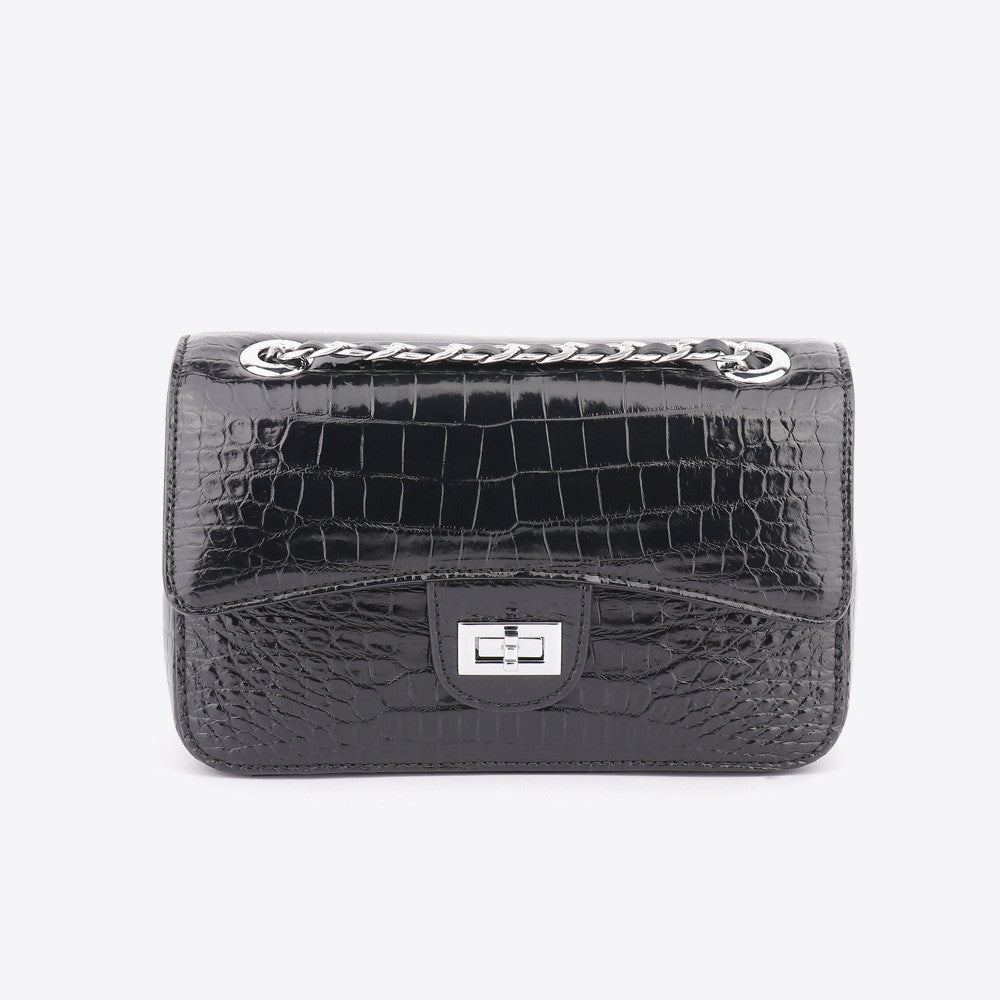 Black crocodile-patterned handbag with silver clasp on a white background