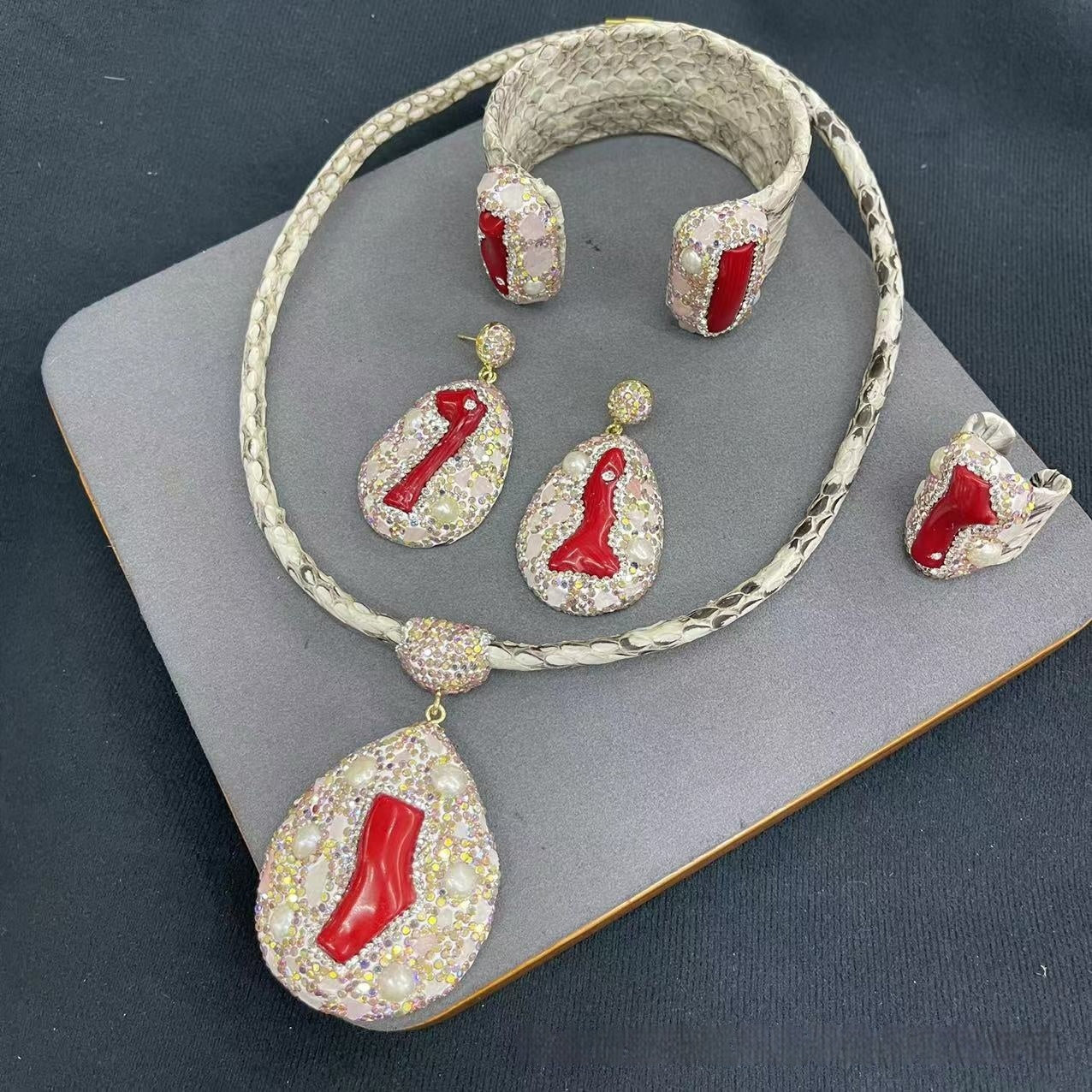 Jewelry set with necklace, earrings, and bracelet on a dark surface