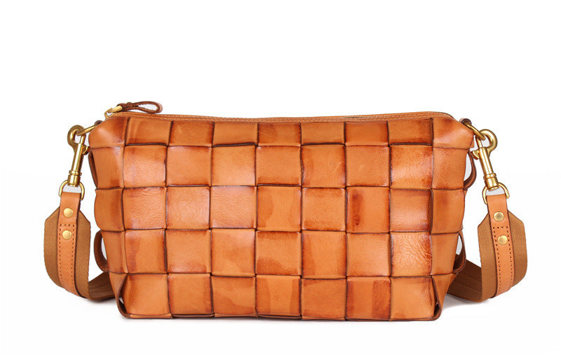Brown woven handbag with gold accents on a white background