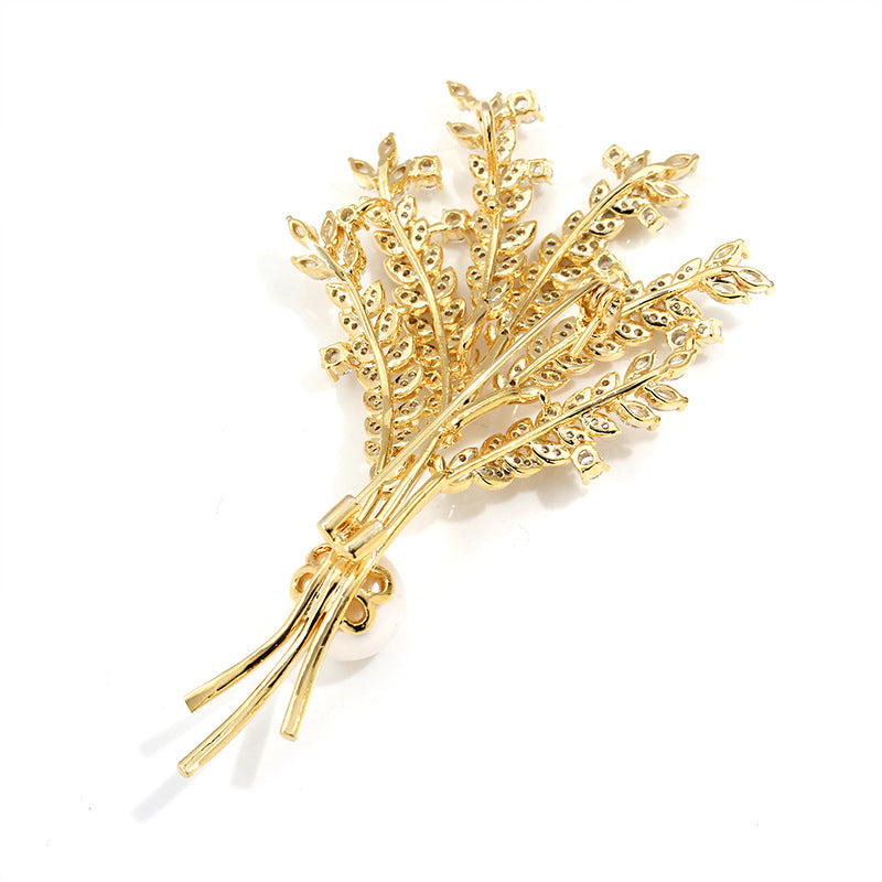 Gold leaf brooch on a white background