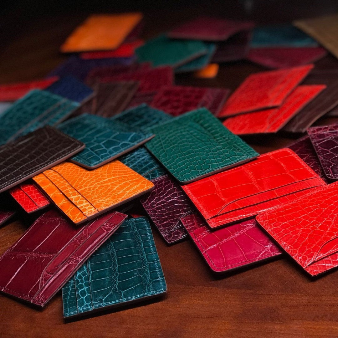 Collection of colorful leather card holders on a wooden surface