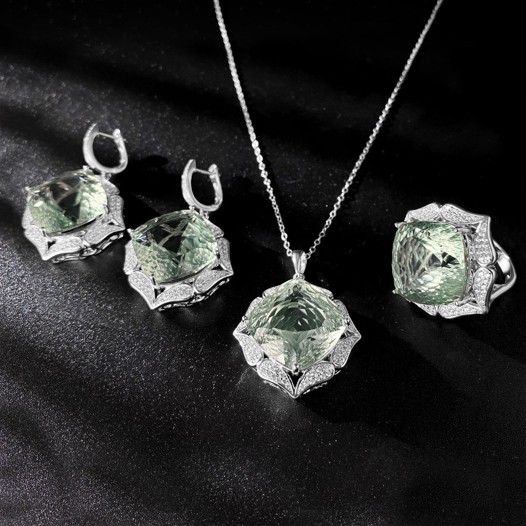 Jewelry set with pendant, earrings, and ring featuring green gemstones on a black background