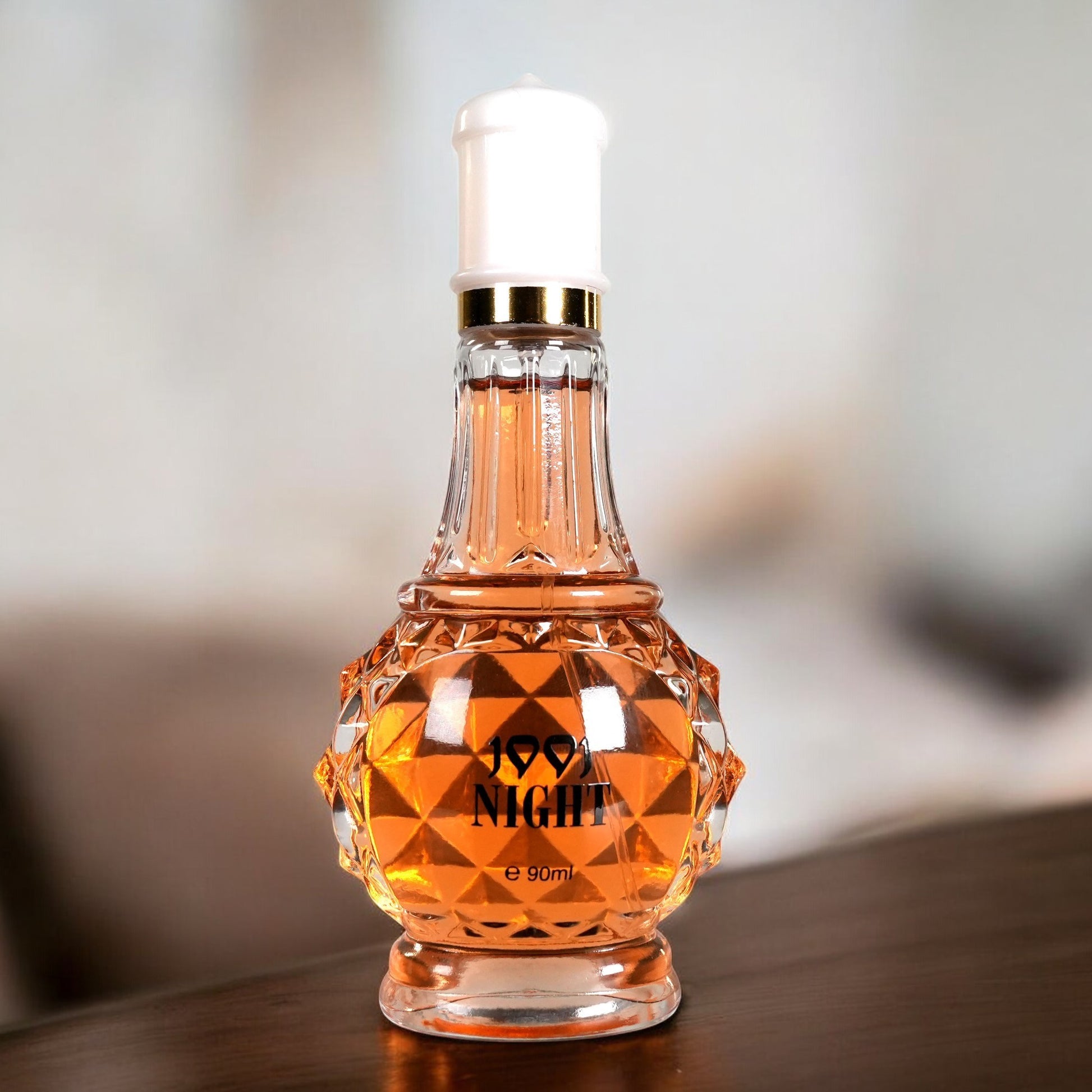 Perfume bottle labeled '99.9 Night' on a wooden surface with a blurred background