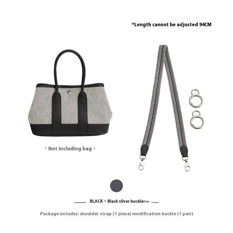 Gray handbag with black straps and a detachable shoulder strap on a white background