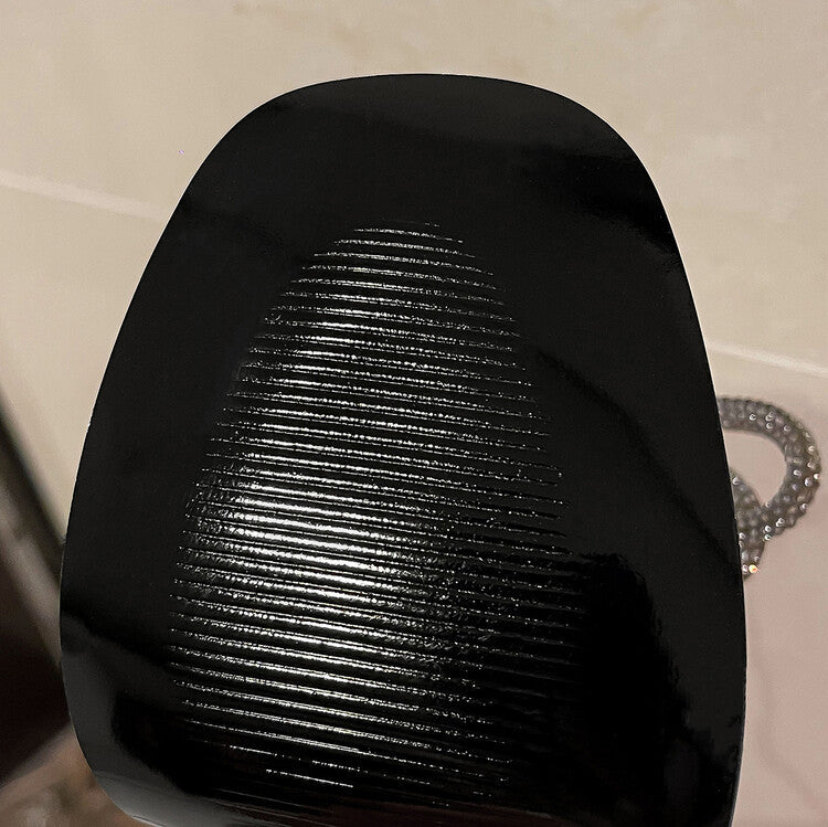 Black textured object on a beige background