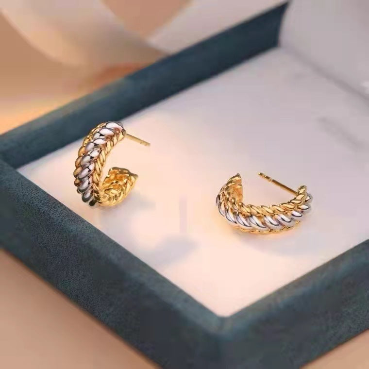 Gold and silver hoop earrings on a soft surface