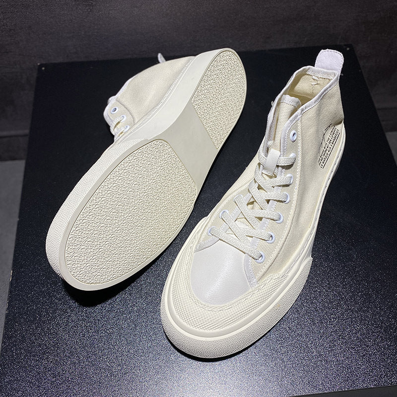 Pair of beige high-top sneakers on a black background