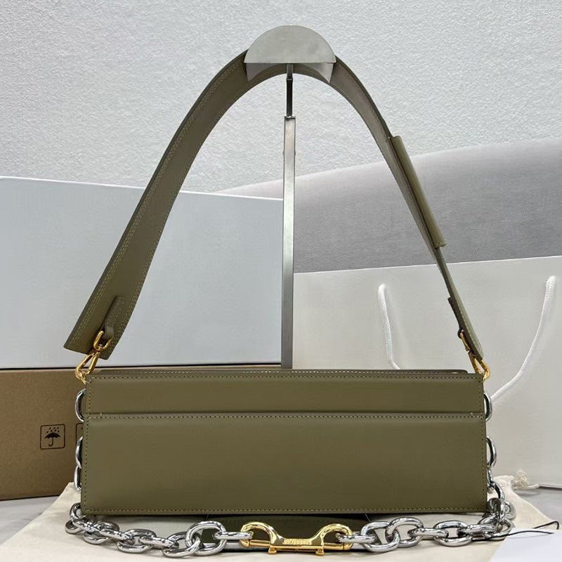 Green handbag with chain detail on a light gray background