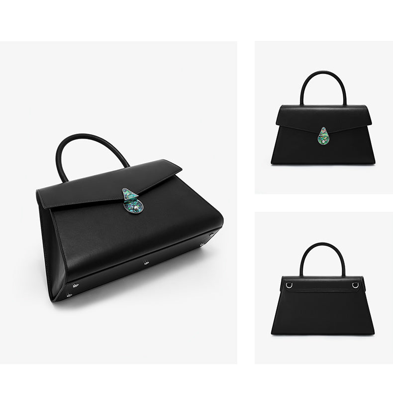 Black handbag with a decorative element on a white background