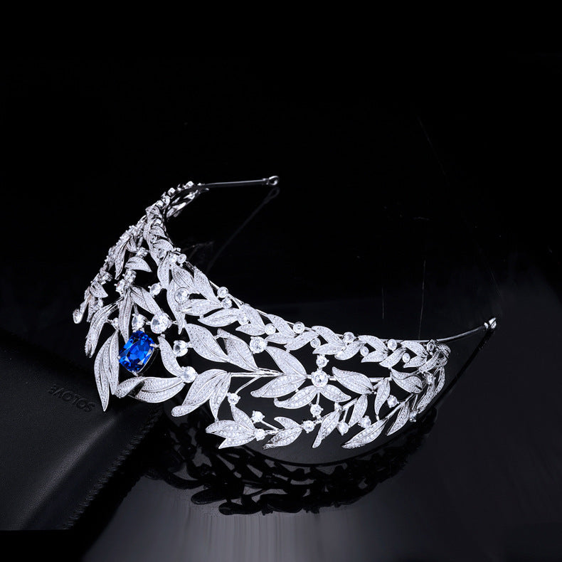 Silver leaf tiara with a blue gemstone on a black background