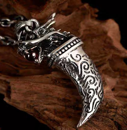 Silver dragon necklace on a wooden background
