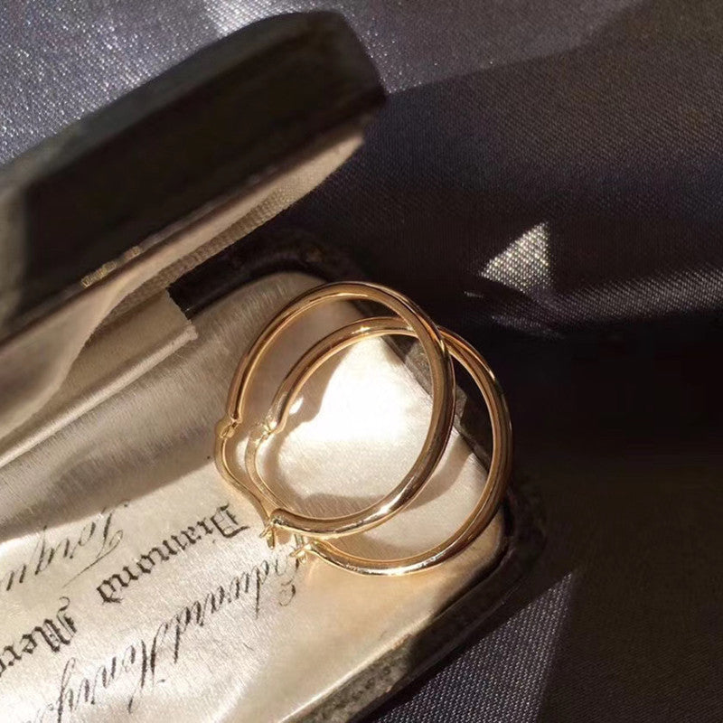Gold hoop earrings on an old letter with a black background