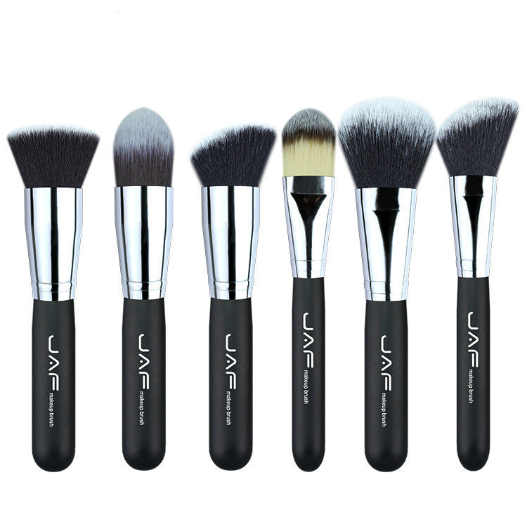 Set of makeup brushes with black handles and silver ferrules on a white background