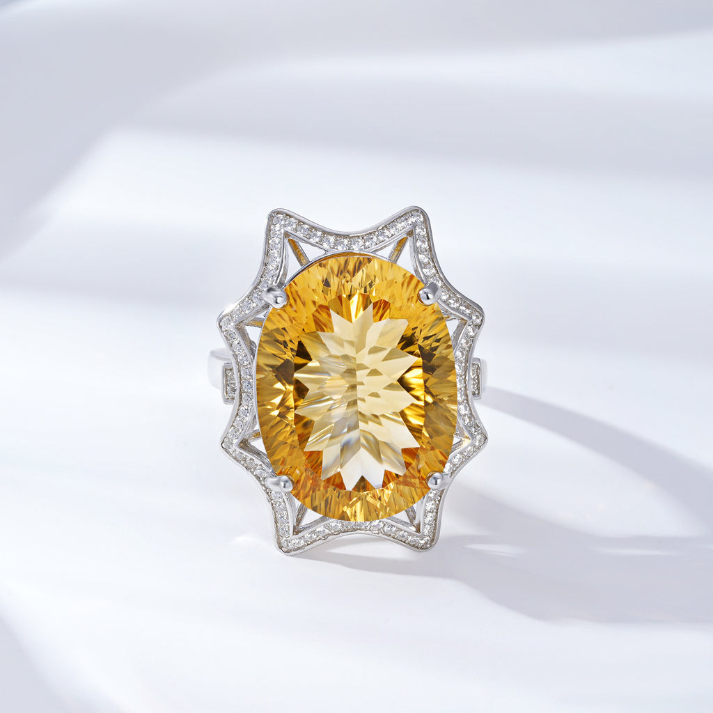 Ring with a large yellow gemstone and diamond-studded band on a white background