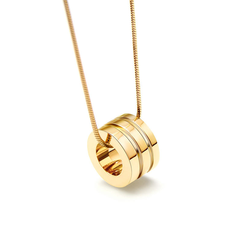 Gold necklace with a circular pendant on a white background