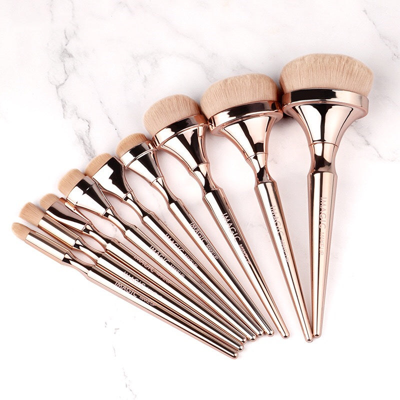 Set of rose gold makeup brushes on a marble surface