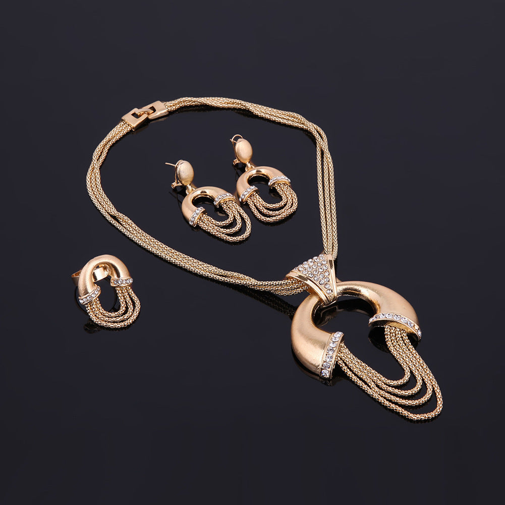 Gold jewelry set with necklace and earrings on a black background