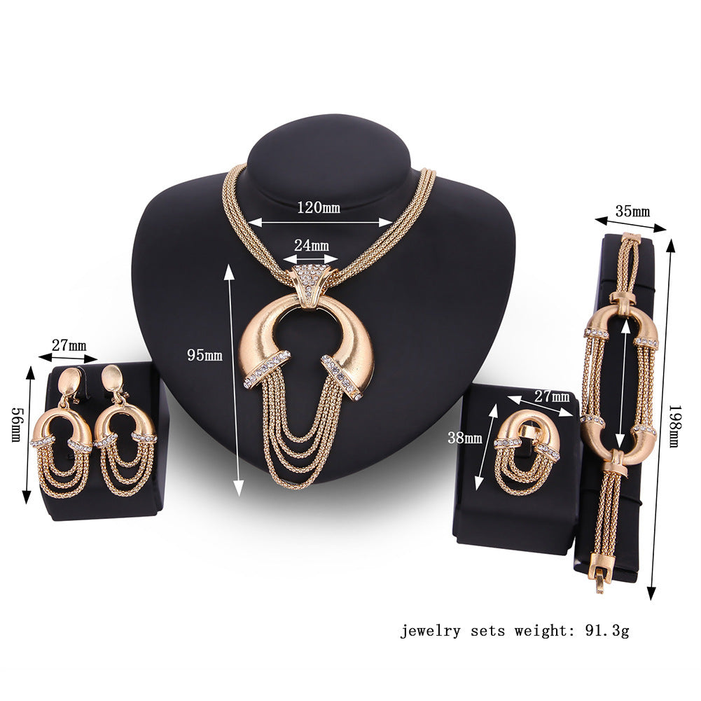 Gold jewelry set with necklace, earrings, and bracelet on a black stand with measurements.