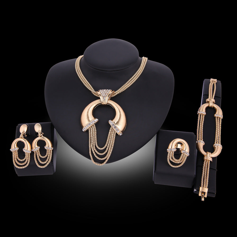 Gold jewelry set including necklace, earrings, and bracelet on a black background