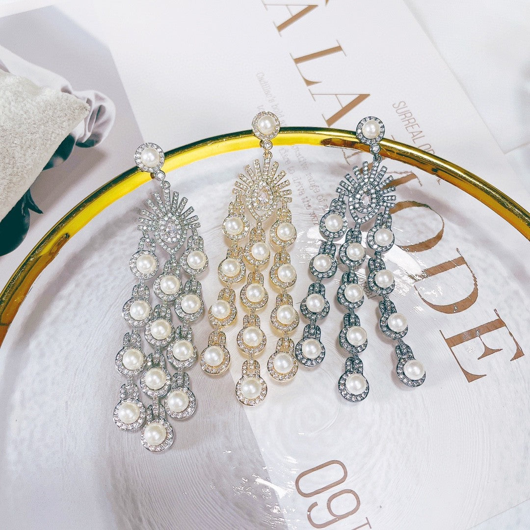 Three pairs of pearl earrings on a decorative plate with text in the background