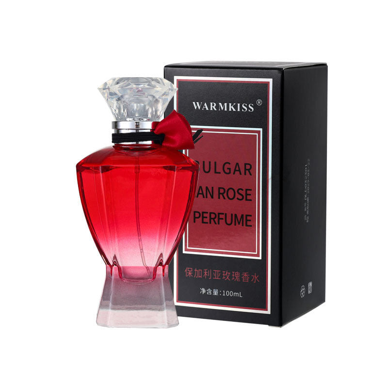 Red perfume bottle with diamond-shaped cap and black box labeled 'WARMKISS' on a white background