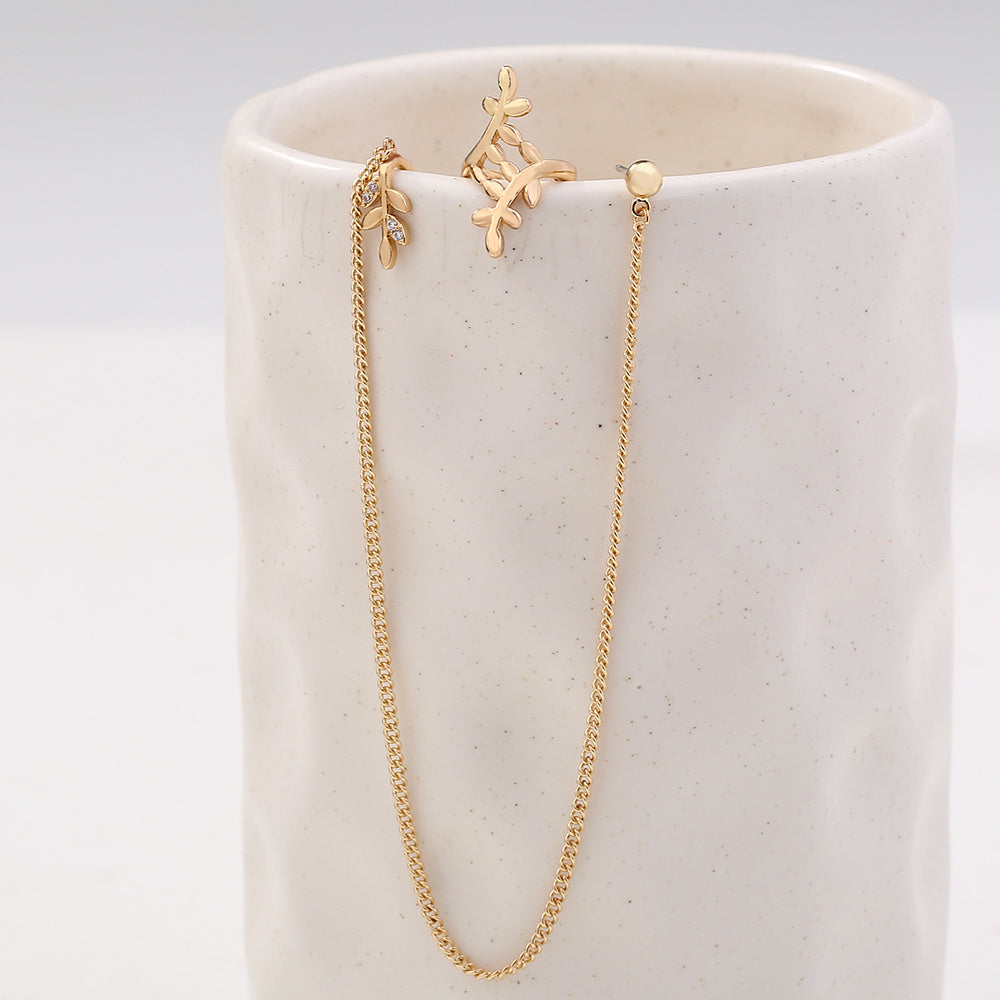 Gold necklace and earrings on a white ceramic stand