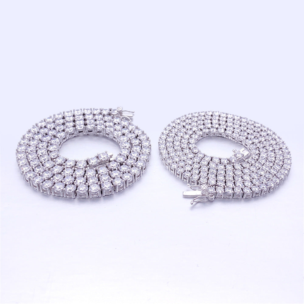 Two diamond-encrusted necklaces on a light purple background
